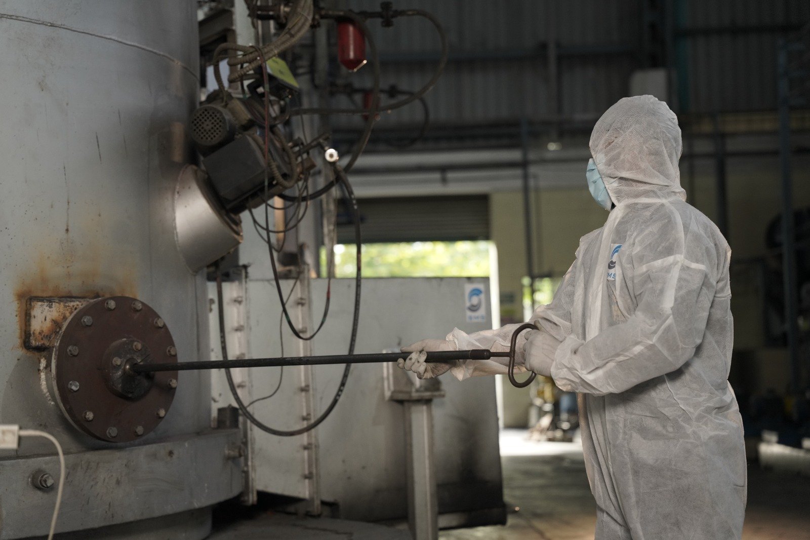 Bio-Medical Waste Treatment Equipment Protected SMS Envocare operator handling equipment inside a bio-medical waste treatment area.