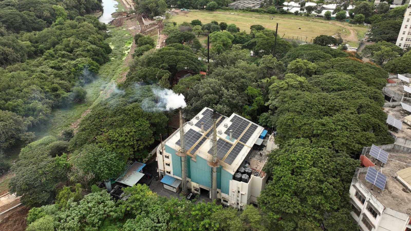 Bio-Medical Waste Facility with Solar Roof Drone view of an SMS Envocare bio-medical waste treatment facility surrounded by trees with solar panels on the roof.